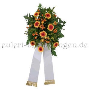 Unaufdringliches Trauergesteck aus orangenen Gerbera und Farn