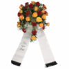 Warm leuchtendes Trauergesteck aus roten und gelben Rosen mit Schleife