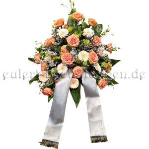Freundliches üppiges Blumengesteck mit Trauerschleife